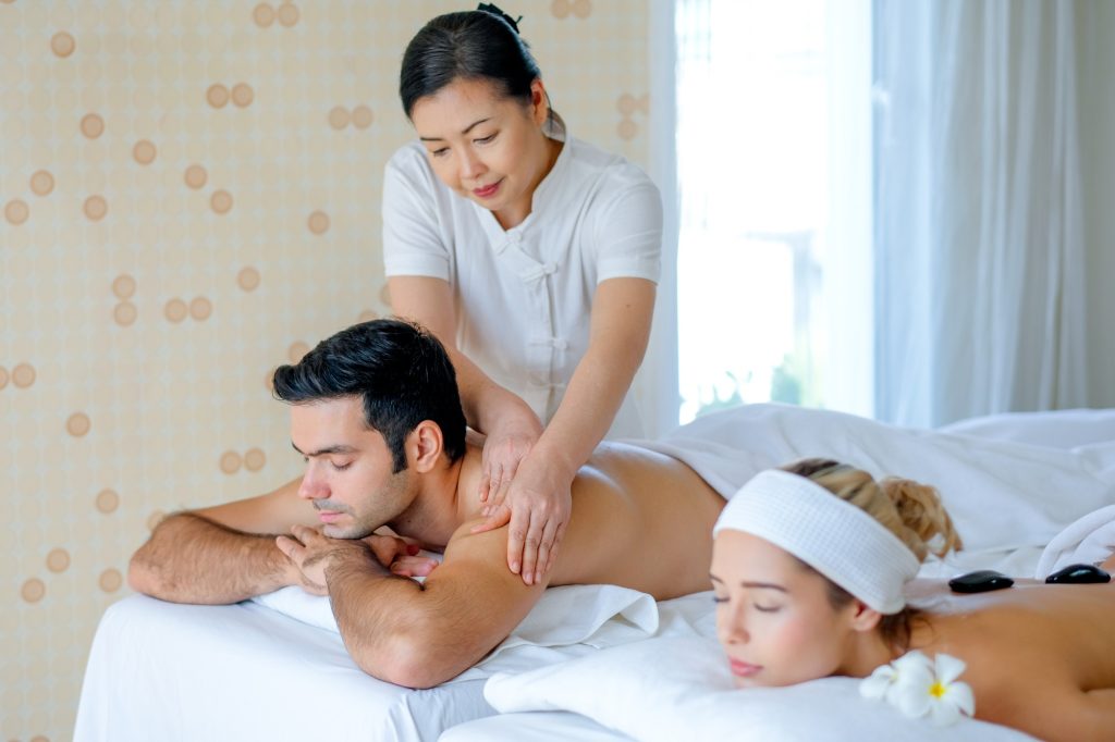 Handsome man enjoy with Thai masseuse massage to him and he lie on bed